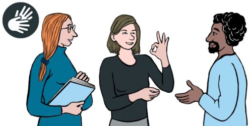 Gebärdendolmetschen ine Frau macht mit der linken Hand ein Zeichen. Sie formt mit Daumen und Zeigefinger einen Kreis. Die anderen Finger sind abgespreizt. Ein Mann mit schwarzem Haar, schwarzem Bart und dunkler Haut steht vor der Frau. Neben ihm ist eine Frau mit Brille und rotem Haar. Beide schauen auf die Frau, die das Handzeichen macht.
